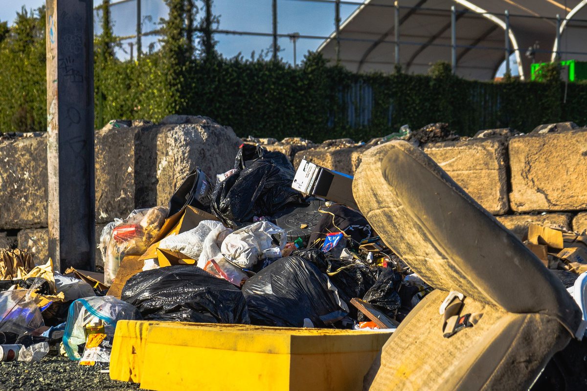Discarded mattress and bulky household items piled outdoors
