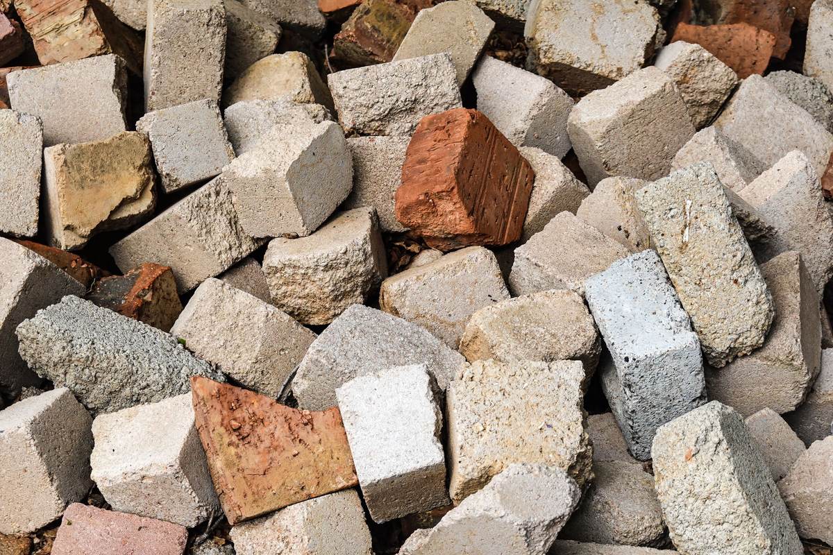 Pile of broken concrete blocks and bricks, a heavy debris type that fills a dumpster's weight limit fast