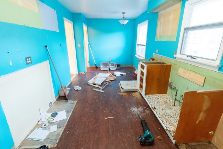 Kitchen being gutted during a remodel with cabinets removed and debris on the floor