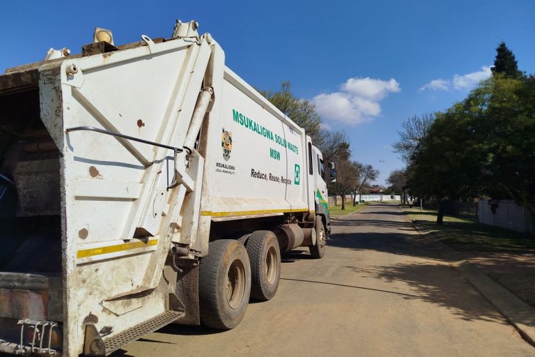 Municipal garbage truck collecting waste on a residential street
