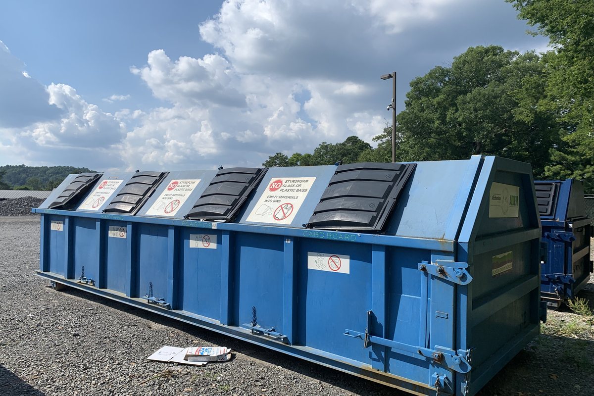Large blue open-top dumpster in a parking lot