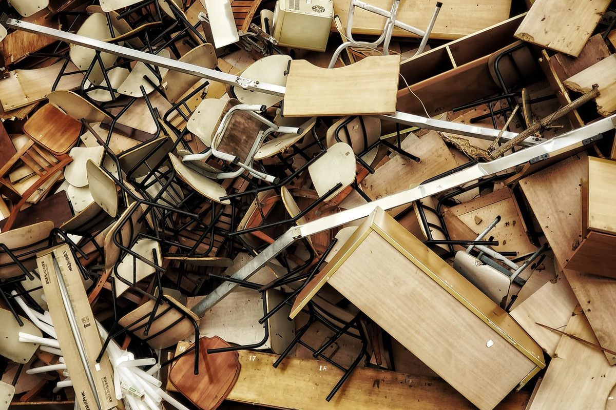 Pile of discarded chairs, desks and old furniture waiting to be hauled away