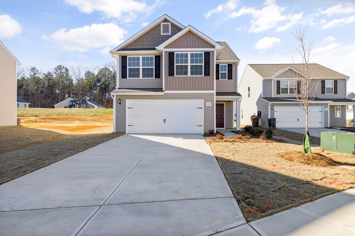 Suburban house with a wide concrete driveway where a roll-off dumpster could be placed